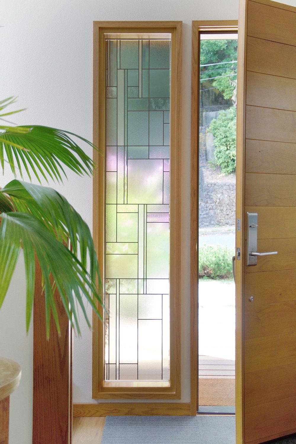 Modern Entryway with Vertical Stained Glass Sidelight and Wood Door