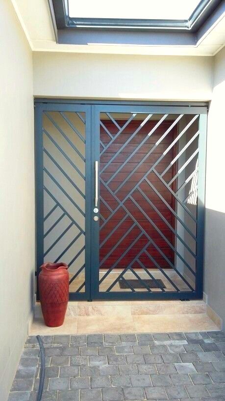 Modern Entryway with Geometric Steel Security Gate and Skylight